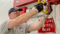 Firefighter twisting a valve.